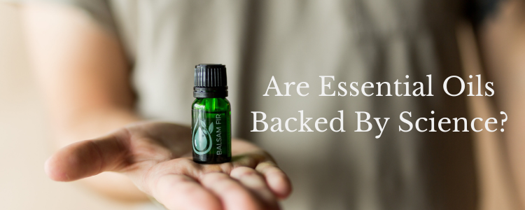 Outstretched hand holding green bottle of Jade Bloom Balsam Fir essential oil. Are Essential Oils Backed By Science